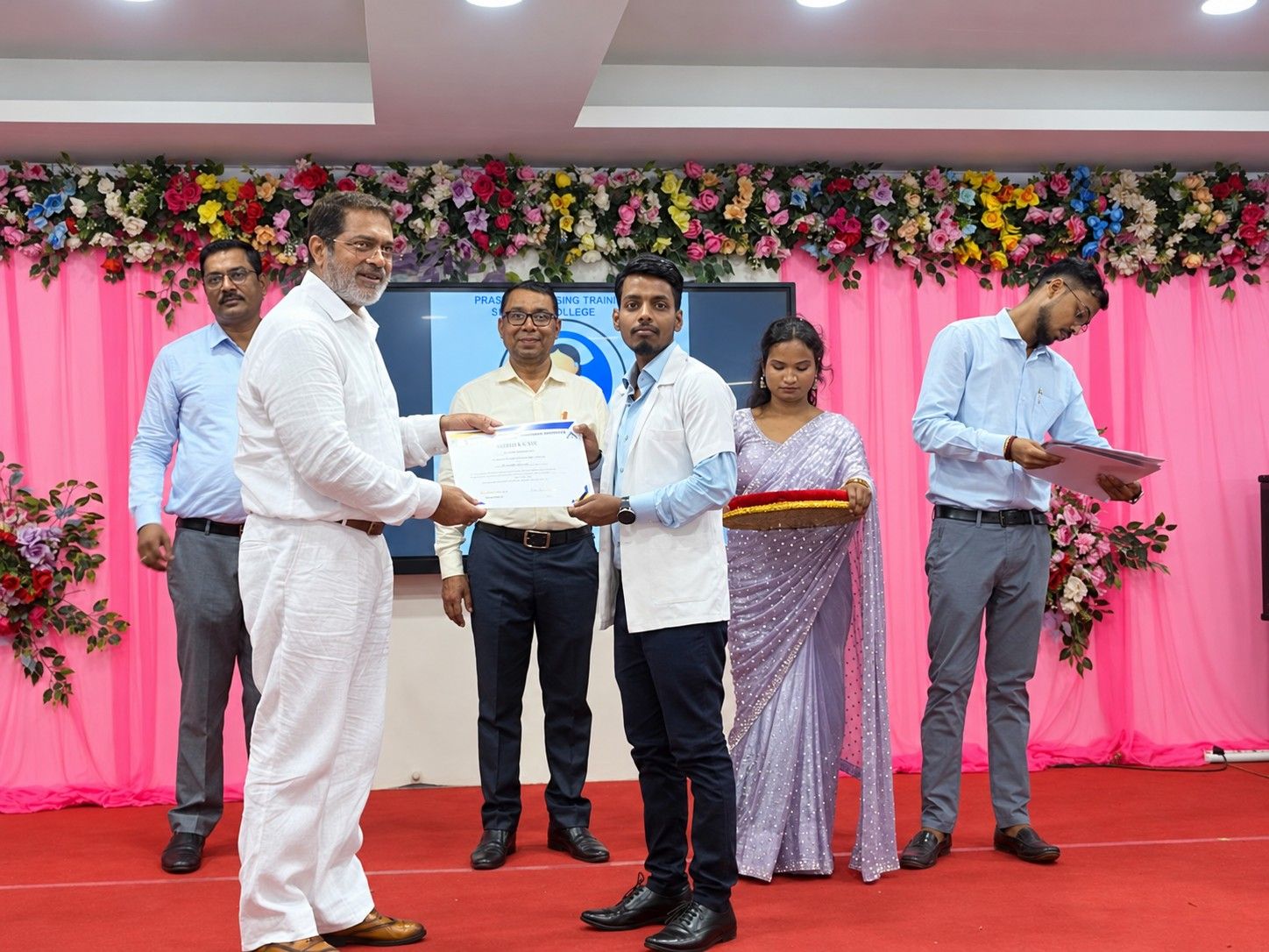 A student receives a certificate at a college ceremony