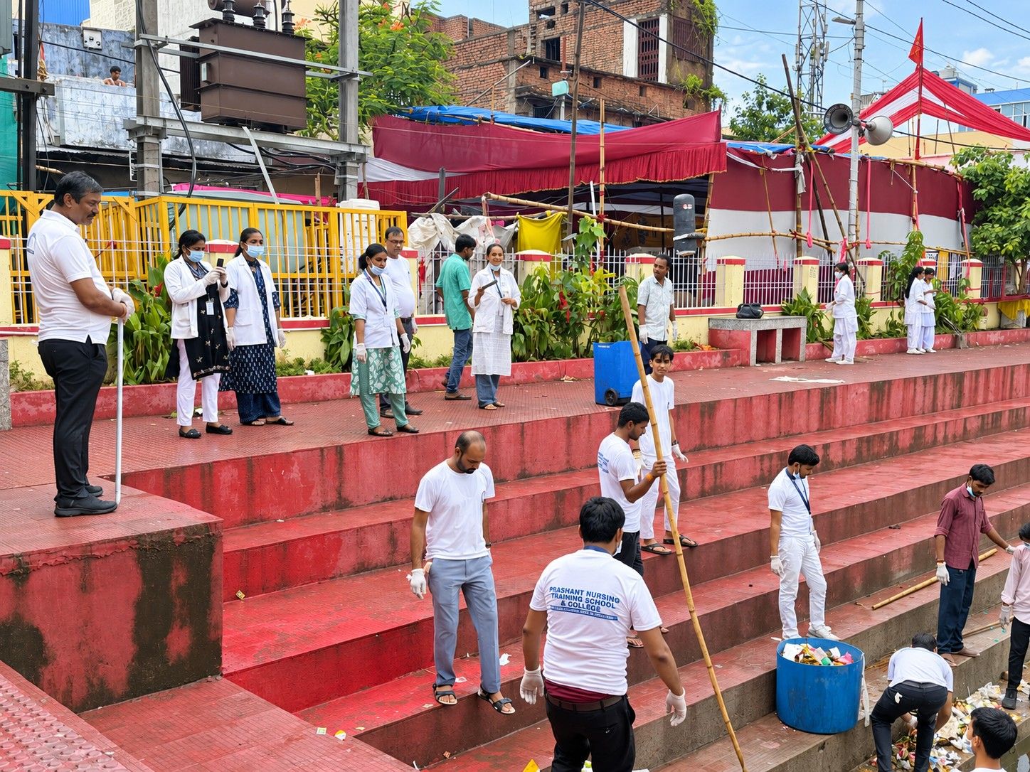 Students clearing litter from the steps of a pond